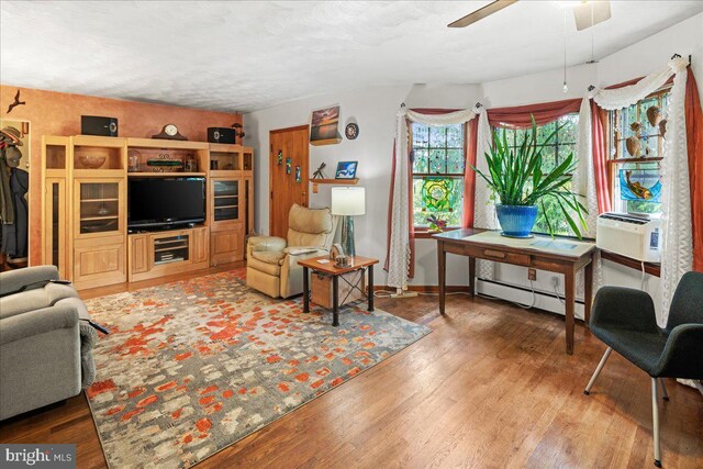 living room with a baseboard heating unit, ceiling fan, and hardwood / wood-style flooring