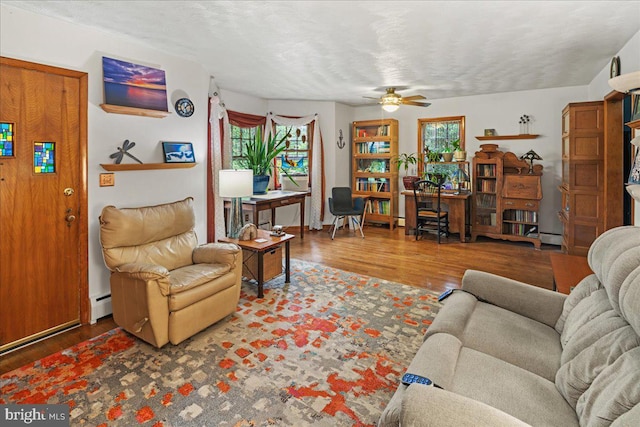 living room with a textured ceiling, a baseboard radiator, ceiling fan, and hardwood / wood-style flooring