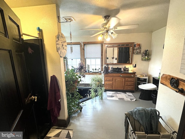 kitchen featuring ceiling fan and a textured ceiling