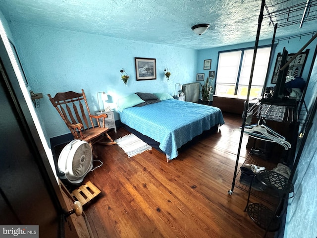 bedroom with hardwood / wood-style floors and a textured ceiling