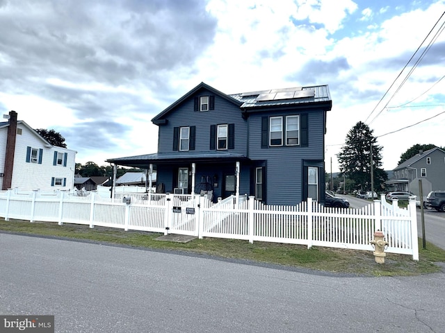 view of front of home featuring solar panels and covered porch