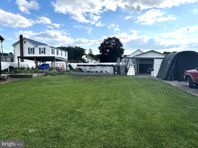 view of yard featuring a garage, a carport, and an outdoor structure