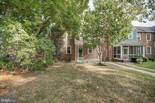 view of front facade featuring a sunroom and a front lawn