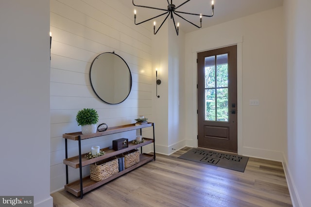 entryway with light hardwood / wood-style flooring and a chandelier