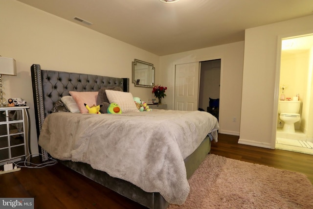 bedroom with ensuite bath, dark wood-type flooring, and a closet