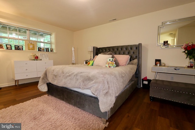 bedroom with dark hardwood / wood-style flooring