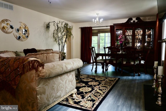 living room with dark wood-type flooring and a chandelier