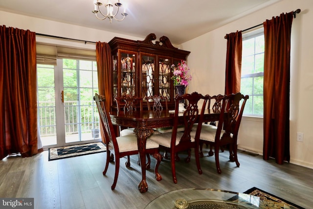 dining area featuring a wealth of natural light, hardwood / wood-style floors, and an inviting chandelier