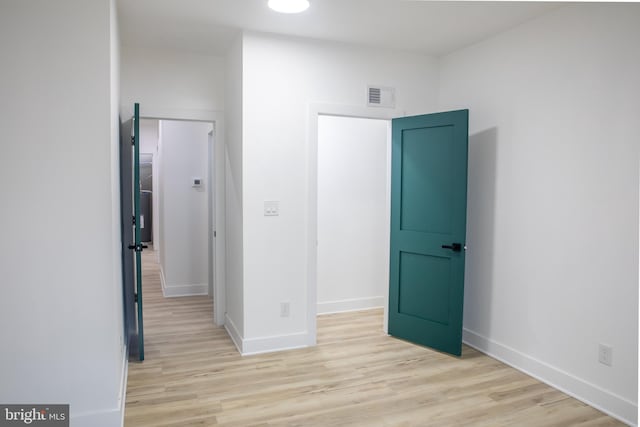 empty room featuring visible vents, baseboards, and light wood-style floors