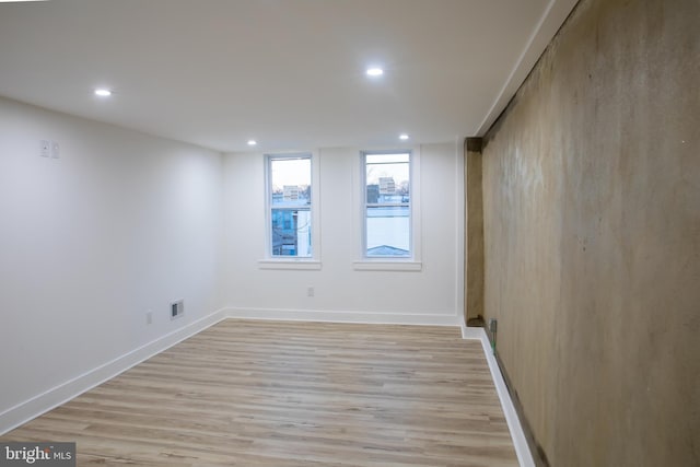 empty room featuring visible vents, recessed lighting, light wood-style floors, and baseboards