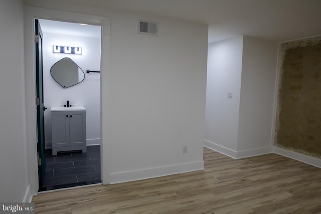 unfurnished room featuring light hardwood / wood-style flooring and sink