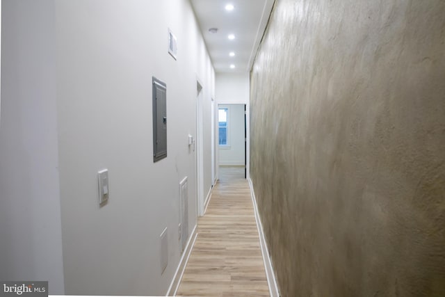 hallway with light hardwood / wood-style flooring and electric panel