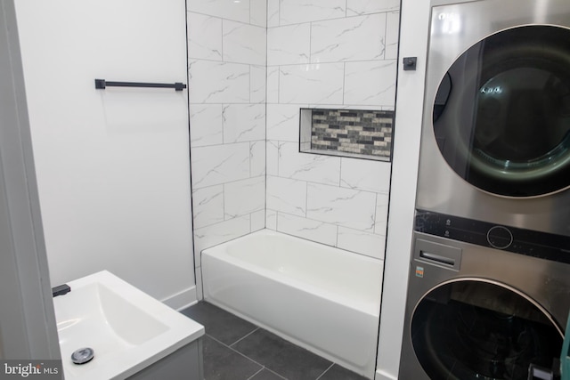 bathroom featuring tile patterned flooring, vanity, tiled shower / bath, and stacked washer / drying machine