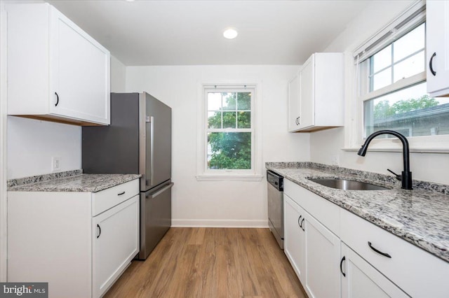 kitchen featuring light wood-type flooring, white cabinetry, sink, and appliances with stainless steel finishes