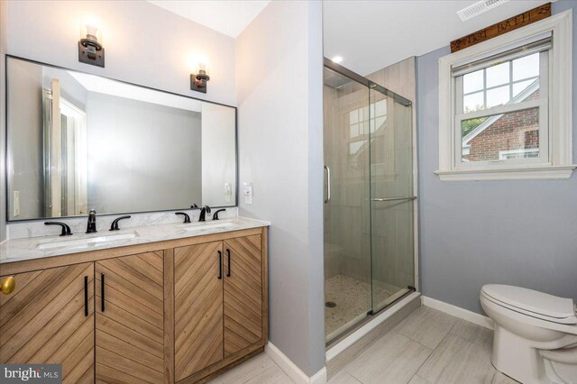 bathroom with tile patterned floors, vanity, toilet, and an enclosed shower