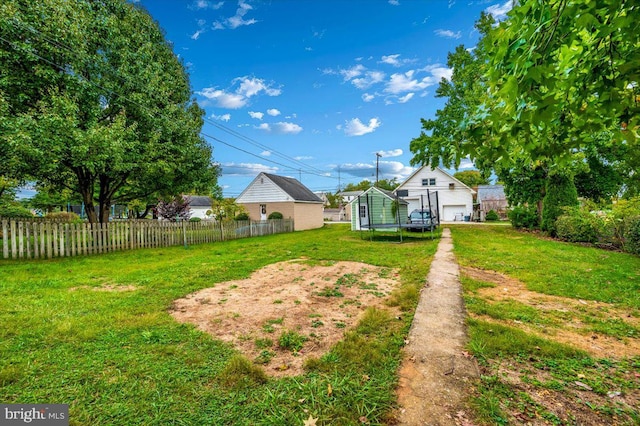 view of yard featuring a trampoline and an outdoor structure