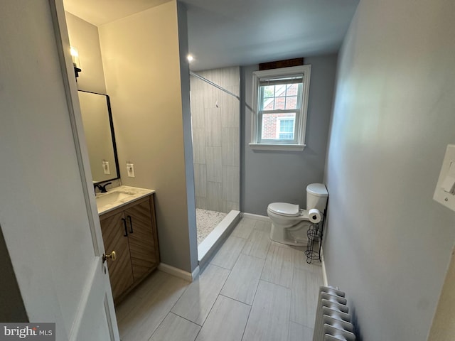 bathroom featuring walk in shower, radiator, vanity, and toilet