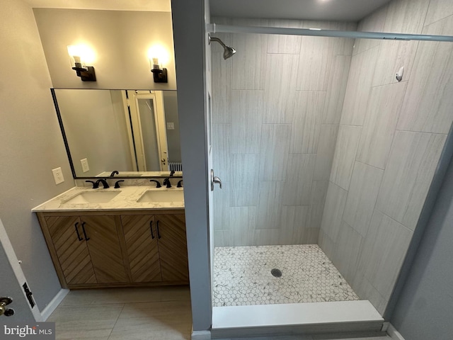 bathroom featuring tiled shower, vanity, and tile patterned flooring