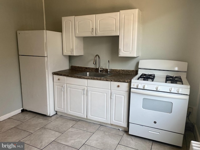 kitchen with white cabinets, white appliances, light tile patterned floors, and sink