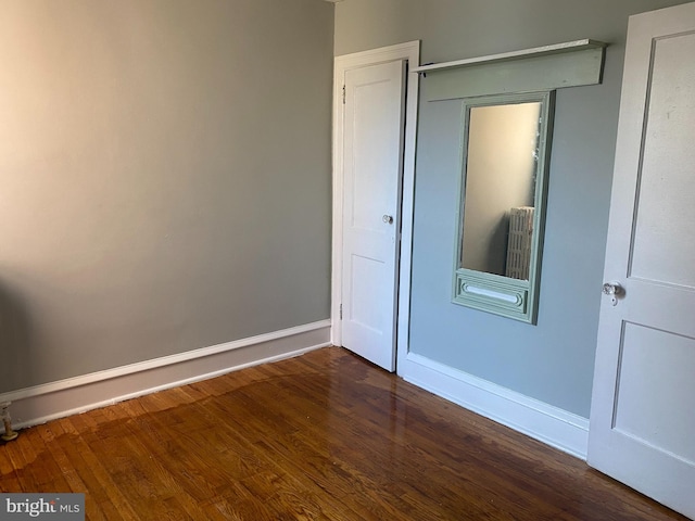 unfurnished bedroom with dark wood-type flooring