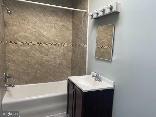 bathroom featuring tiled shower / bath combo and vanity