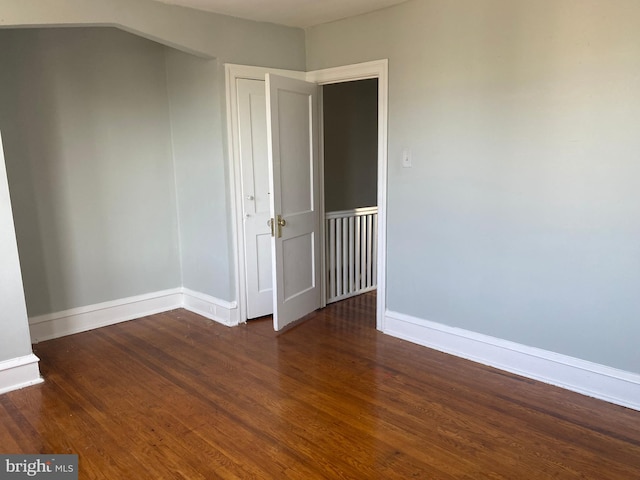 unfurnished room featuring dark wood-type flooring