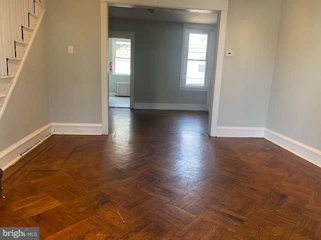 unfurnished room featuring radiator and dark parquet flooring