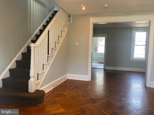 stairs with parquet flooring and radiator heating unit