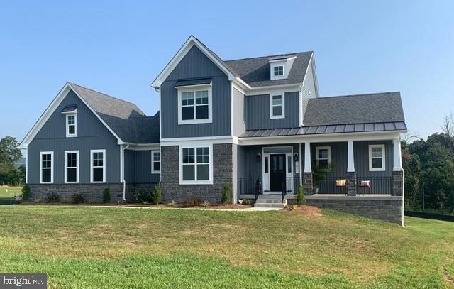 craftsman inspired home with covered porch and a front lawn