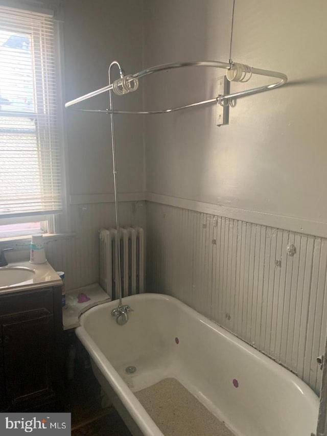 bathroom featuring vanity, a bathing tub, and radiator heating unit