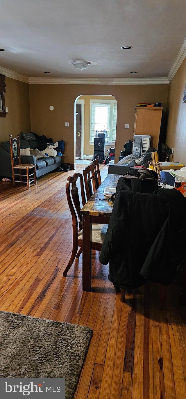 dining space with crown molding and wood-type flooring