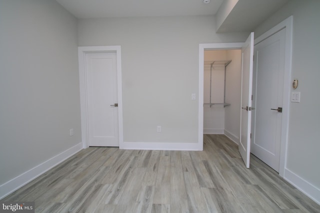 unfurnished bedroom featuring light wood-type flooring and a closet