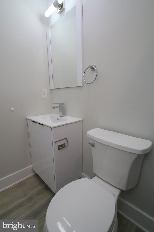 bathroom with vanity, hardwood / wood-style floors, and toilet