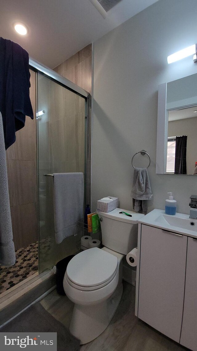 bathroom with vanity, toilet, and an enclosed shower