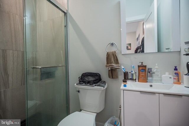 bathroom with vanity, a shower with shower door, and toilet