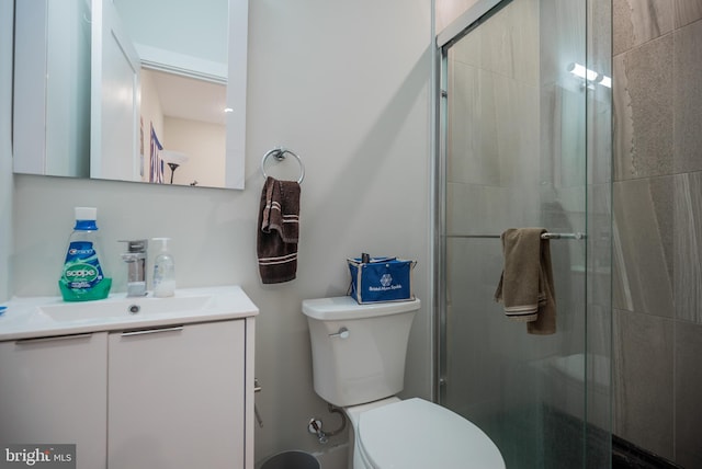 bathroom with vanity, a shower with shower door, and toilet