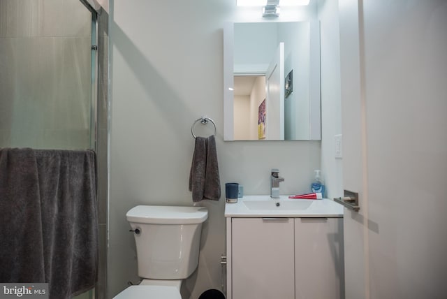 bathroom with an enclosed shower, vanity, and toilet