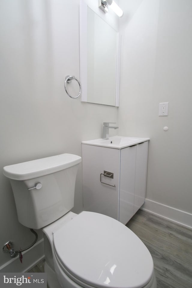 bathroom featuring vanity, toilet, and hardwood / wood-style flooring