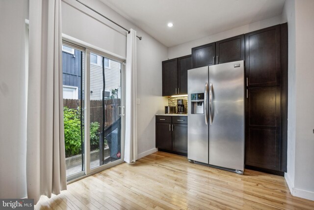 kitchen with light wood-type flooring, a chandelier, stainless steel appliances, decorative light fixtures, and kitchen peninsula