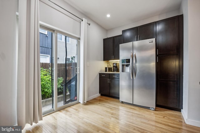 kitchen with stainless steel fridge with ice dispenser, light hardwood / wood-style flooring, and dark brown cabinetry