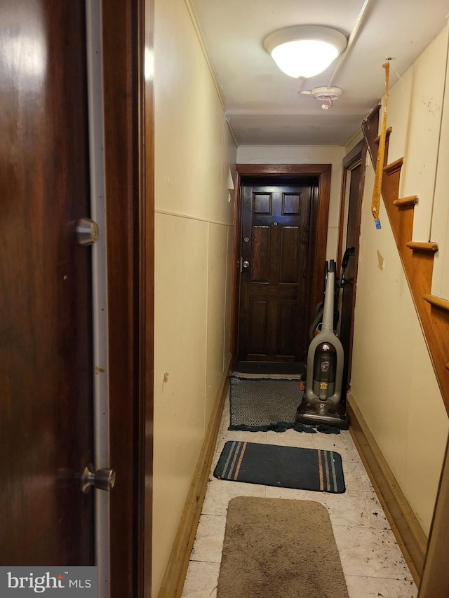 doorway featuring crown molding and stairway