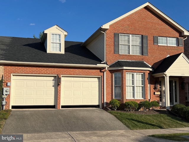 traditional-style house with a garage, brick siding, and driveway