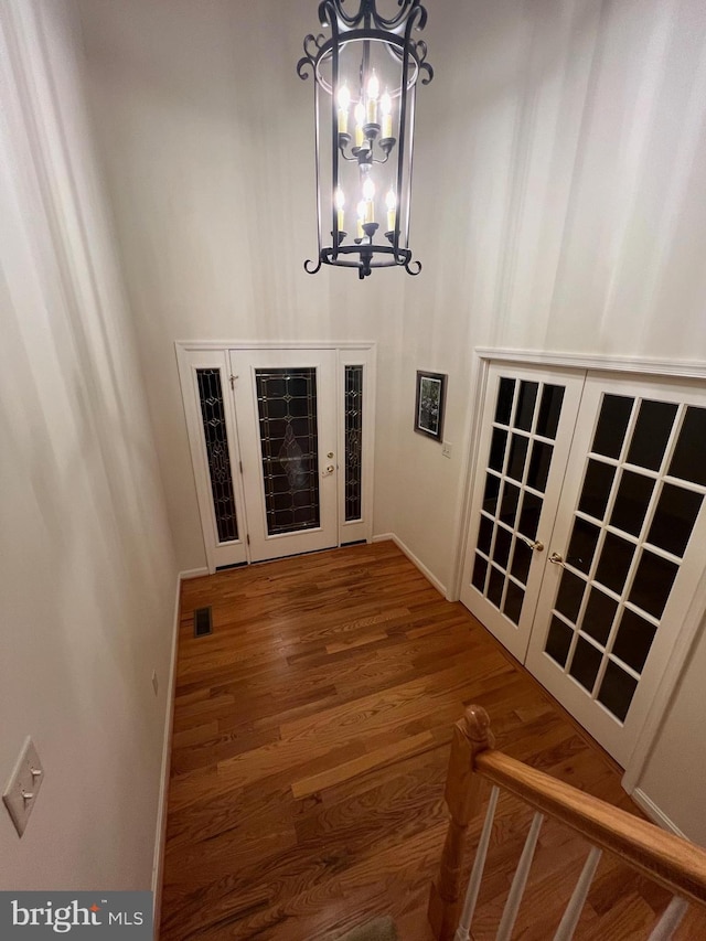 stairway featuring a notable chandelier and hardwood / wood-style floors