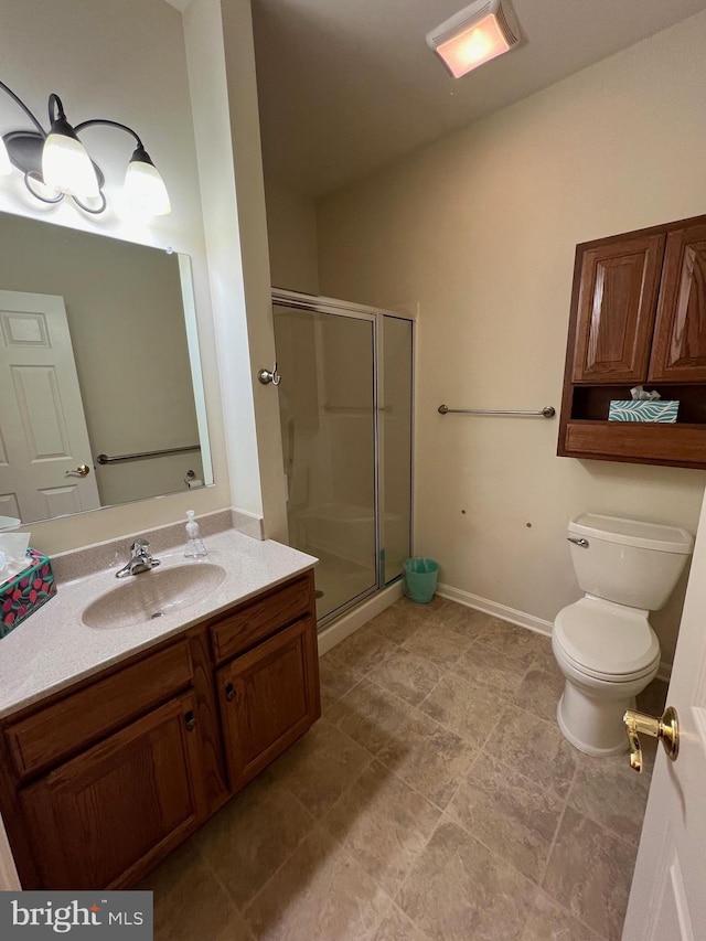 bathroom featuring vanity, toilet, and a shower with door