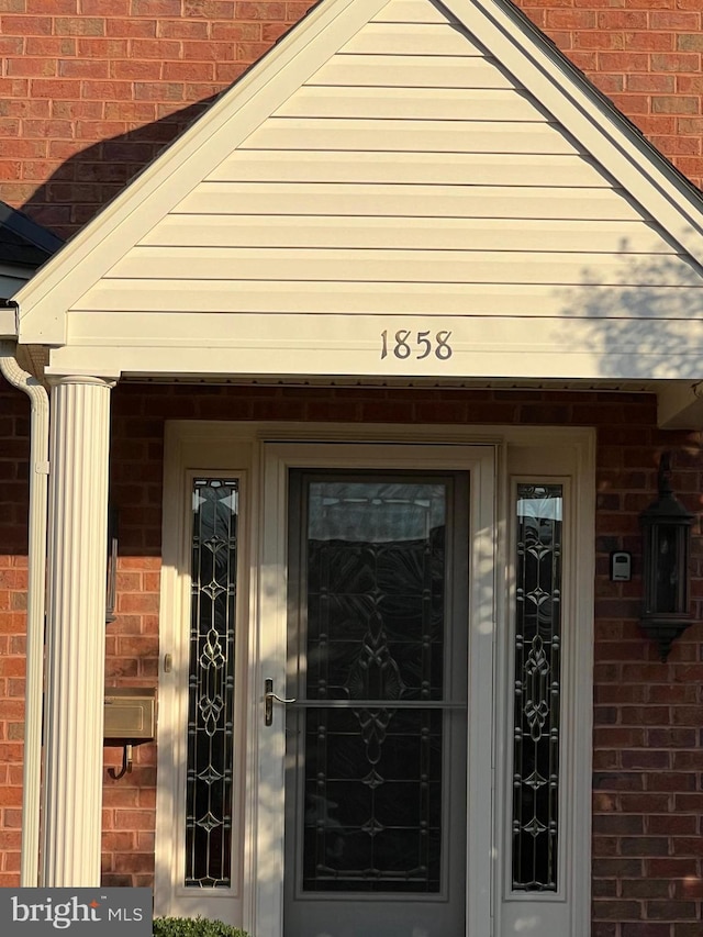 doorway to property featuring brick siding