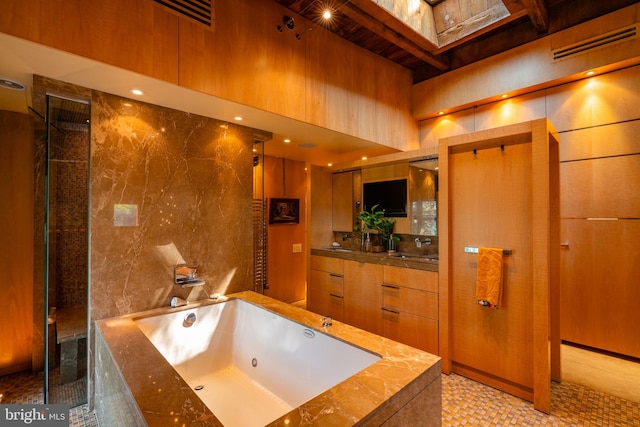 bathroom with vanity, a skylight, and separate shower and tub