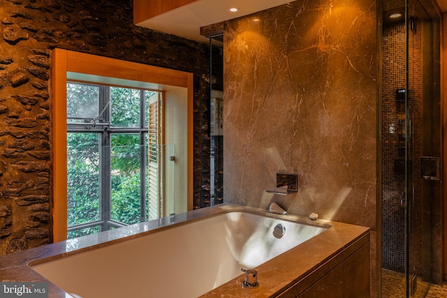 bathroom featuring separate shower and tub