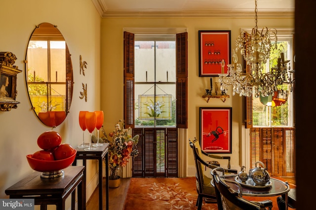 living area with an inviting chandelier, hardwood / wood-style flooring, and crown molding