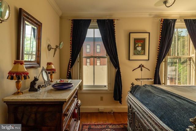 bedroom with crown molding and dark wood-type flooring