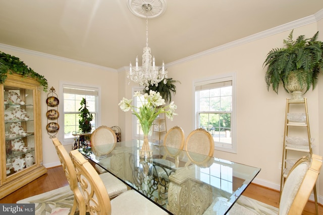 dining space featuring crown molding, hardwood / wood-style flooring, and a notable chandelier